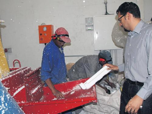 Noel Ehrenreich demonstrates how polystyrene is fed into the machine.